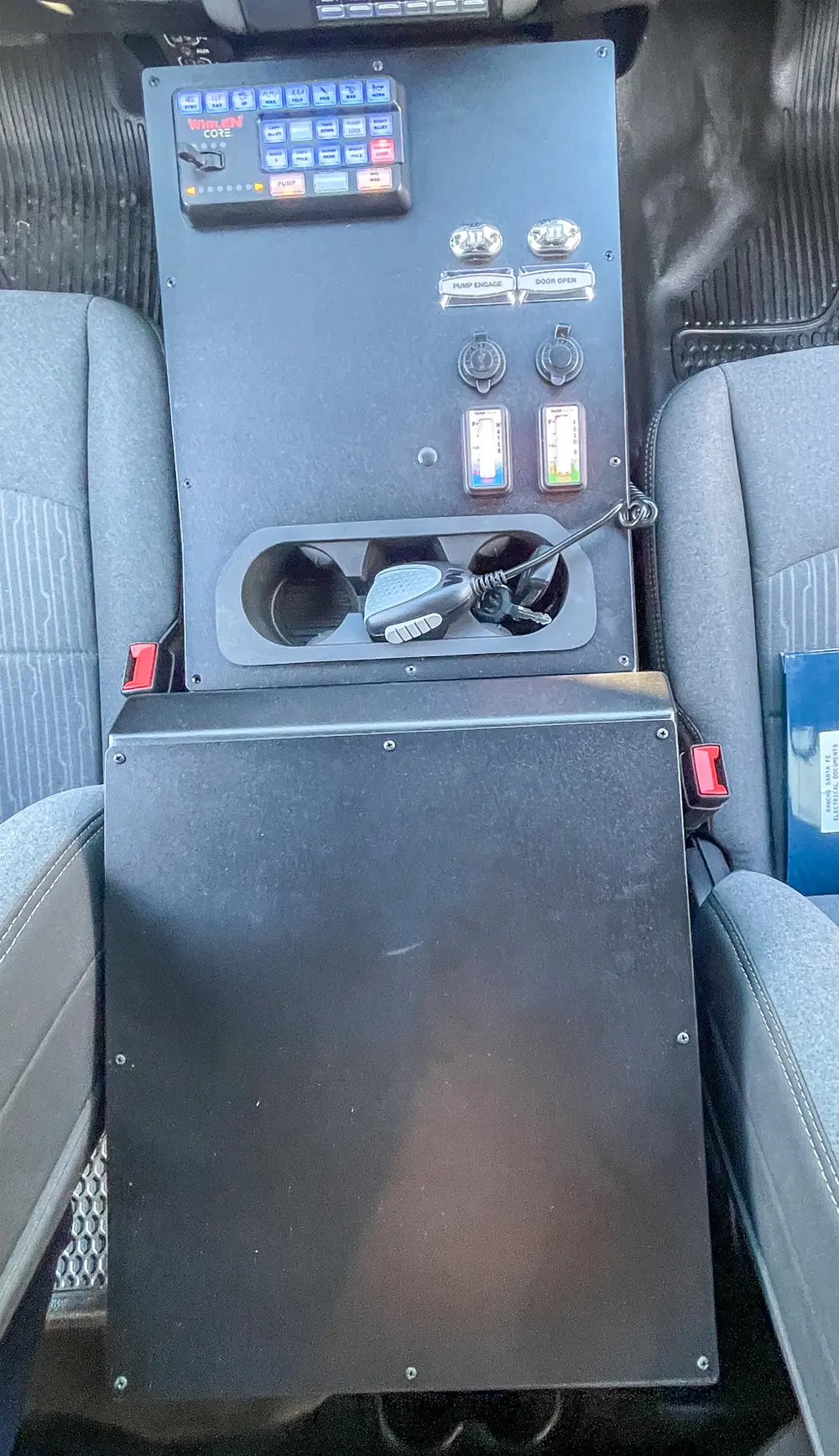 Exterior view of small fire truck showing cab, body compartments, and wheel/tire area.