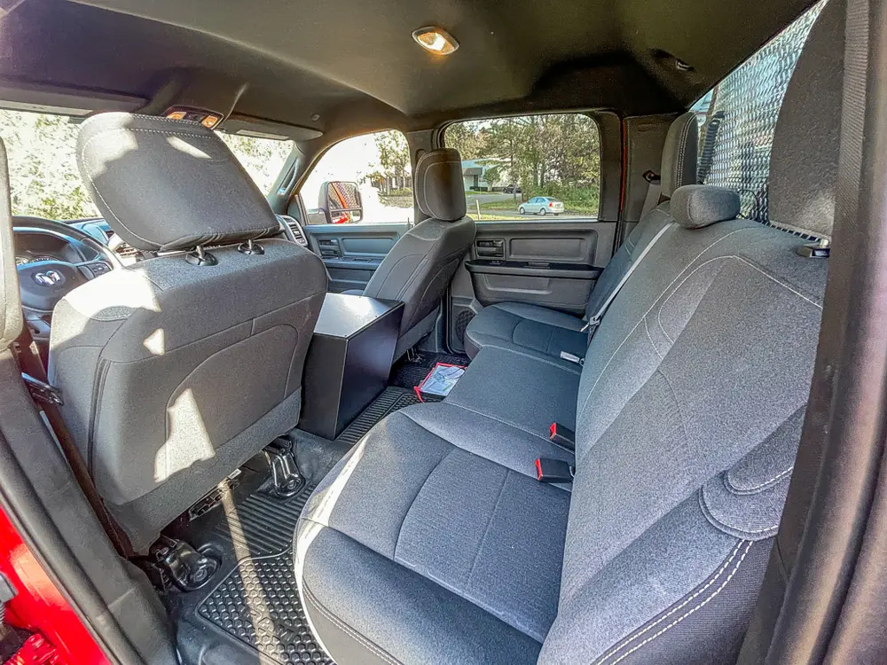 Exterior view of small fire truck showing cab, body compartments, and wheel/tire area.