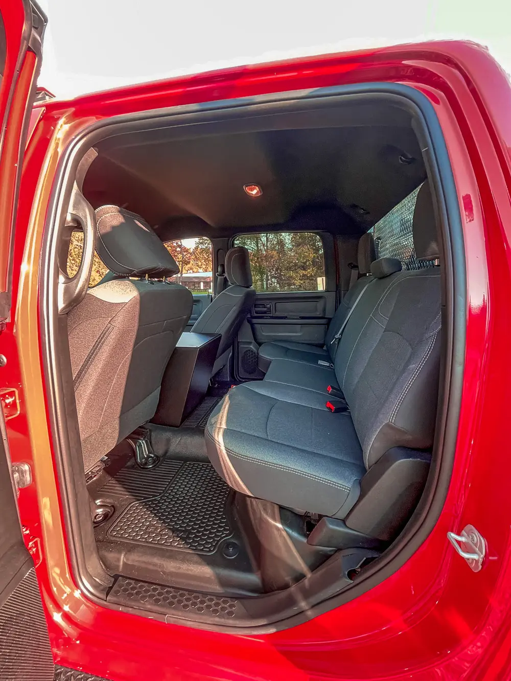 Exterior view of small fire truck showing cab, body compartments, and wheel/tire area.