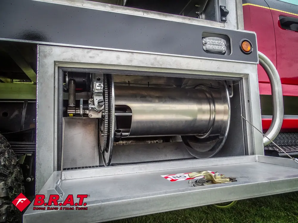 Exterior view of small fire truck showing cab, body compartments, and wheel/tire area.
