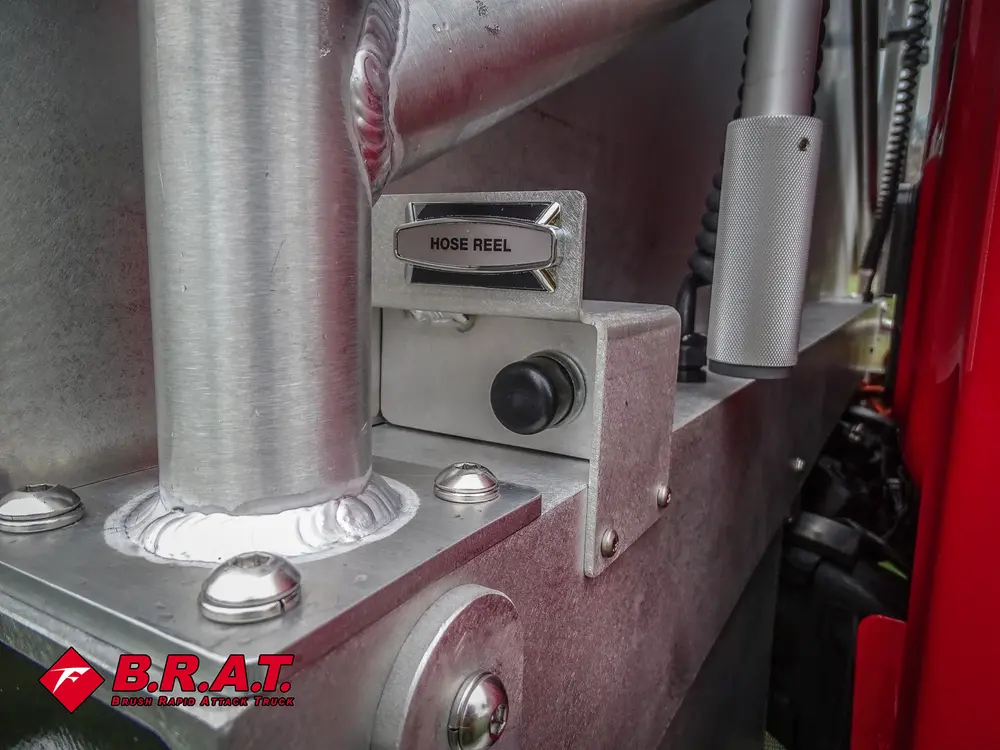 Exterior view of small fire truck showing cab, body compartments, and wheel/tire area.