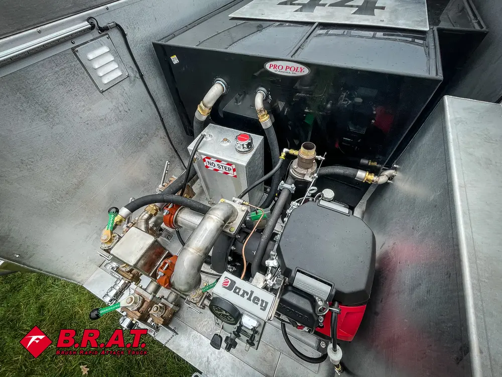 Exterior view of small fire truck showing cab, body compartments, and wheel/tire area.