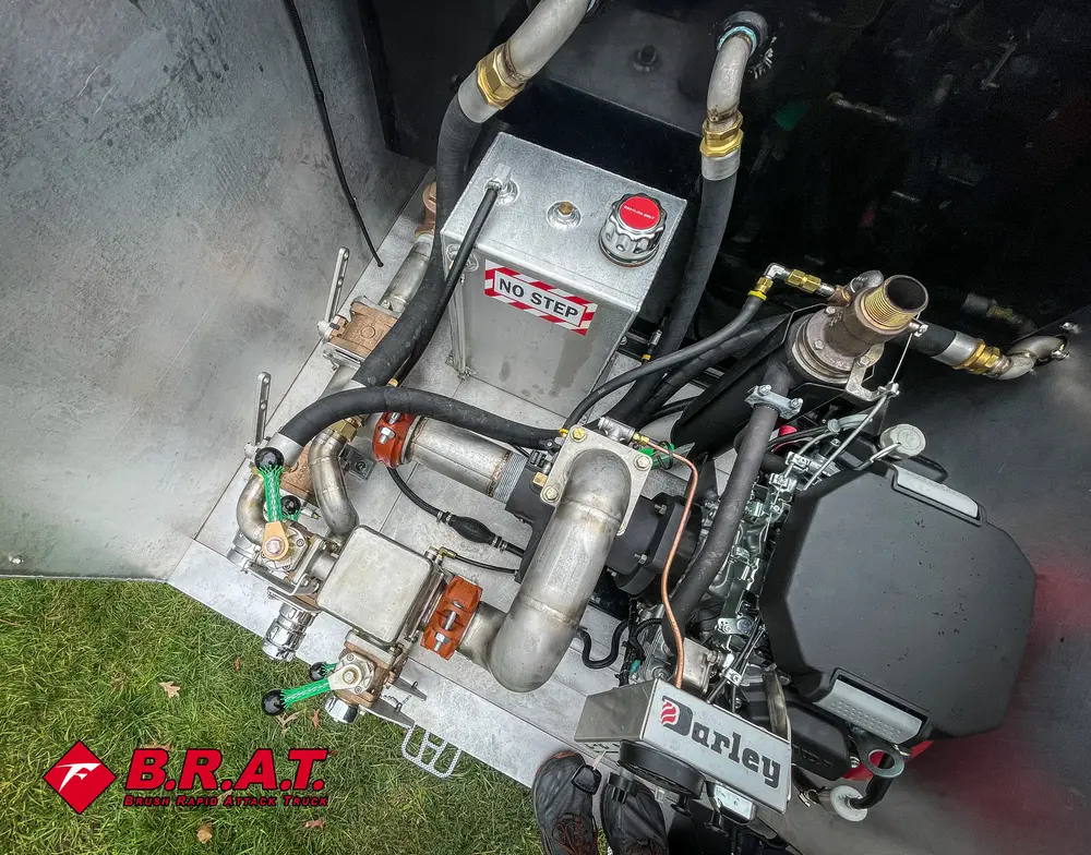 Exterior view of small fire truck showing cab, body compartments, and wheel/tire area.