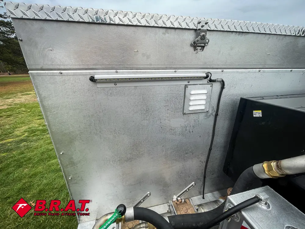 Exterior view of small fire truck showing cab, body compartments, and wheel/tire area.