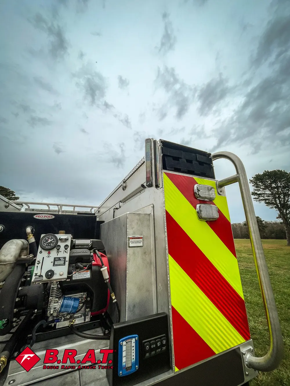 Exterior view of small fire truck showing cab, body compartments, and wheel/tire area.
