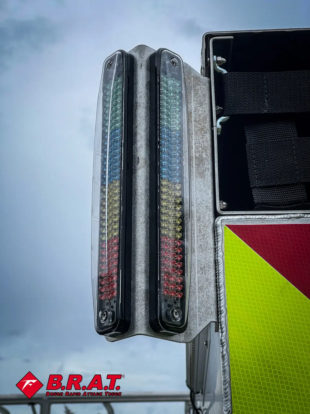 Exterior view of small fire truck showing cab, body compartments, and wheel/tire area.