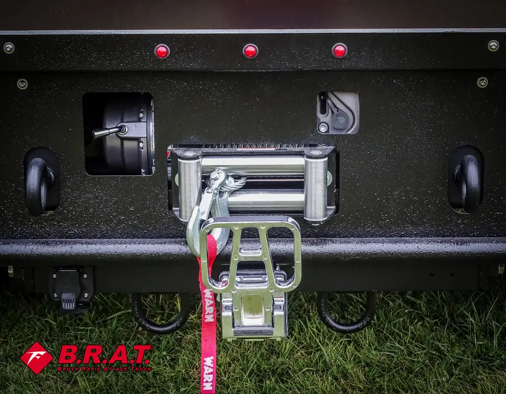 Exterior view of small fire truck showing cab, body compartments, and wheel/tire area.