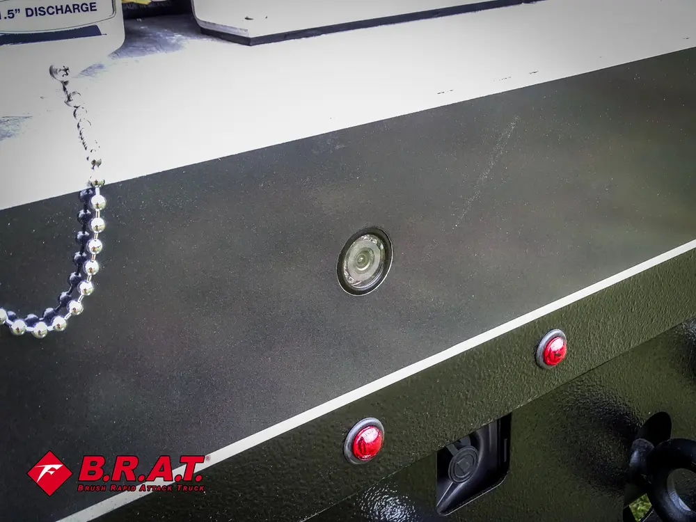 Exterior view of small fire truck showing cab, body compartments, and wheel/tire area.