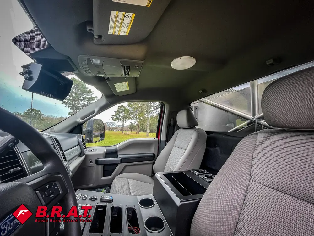 Exterior view of small fire truck showing cab, body compartments, and wheel/tire area.
