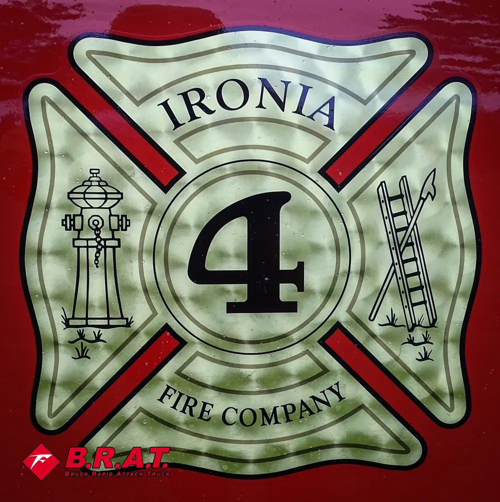 Exterior view of small fire truck showing cab, body compartments, and wheel/tire area.