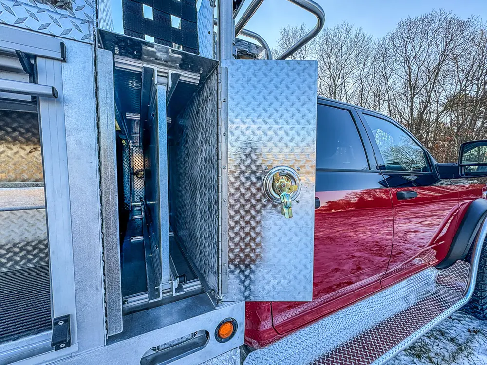 Narrow side compartment opened near the cab with mounted mechanical components.
