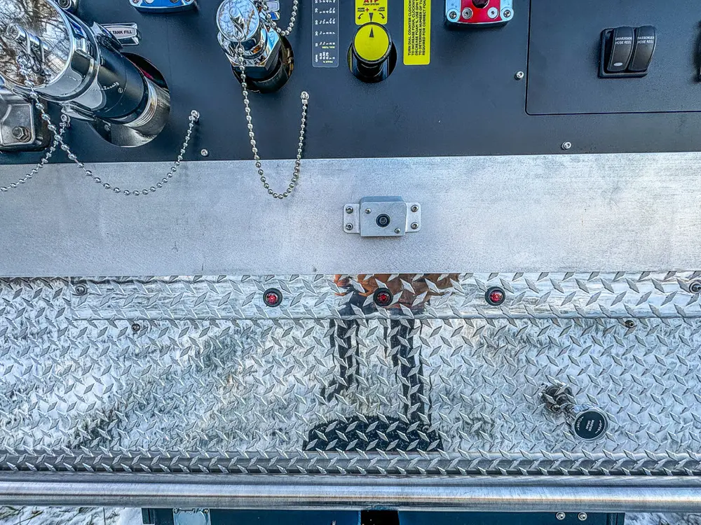 Close-up of the rear diamond-plate step and lower edge of the pump panel.