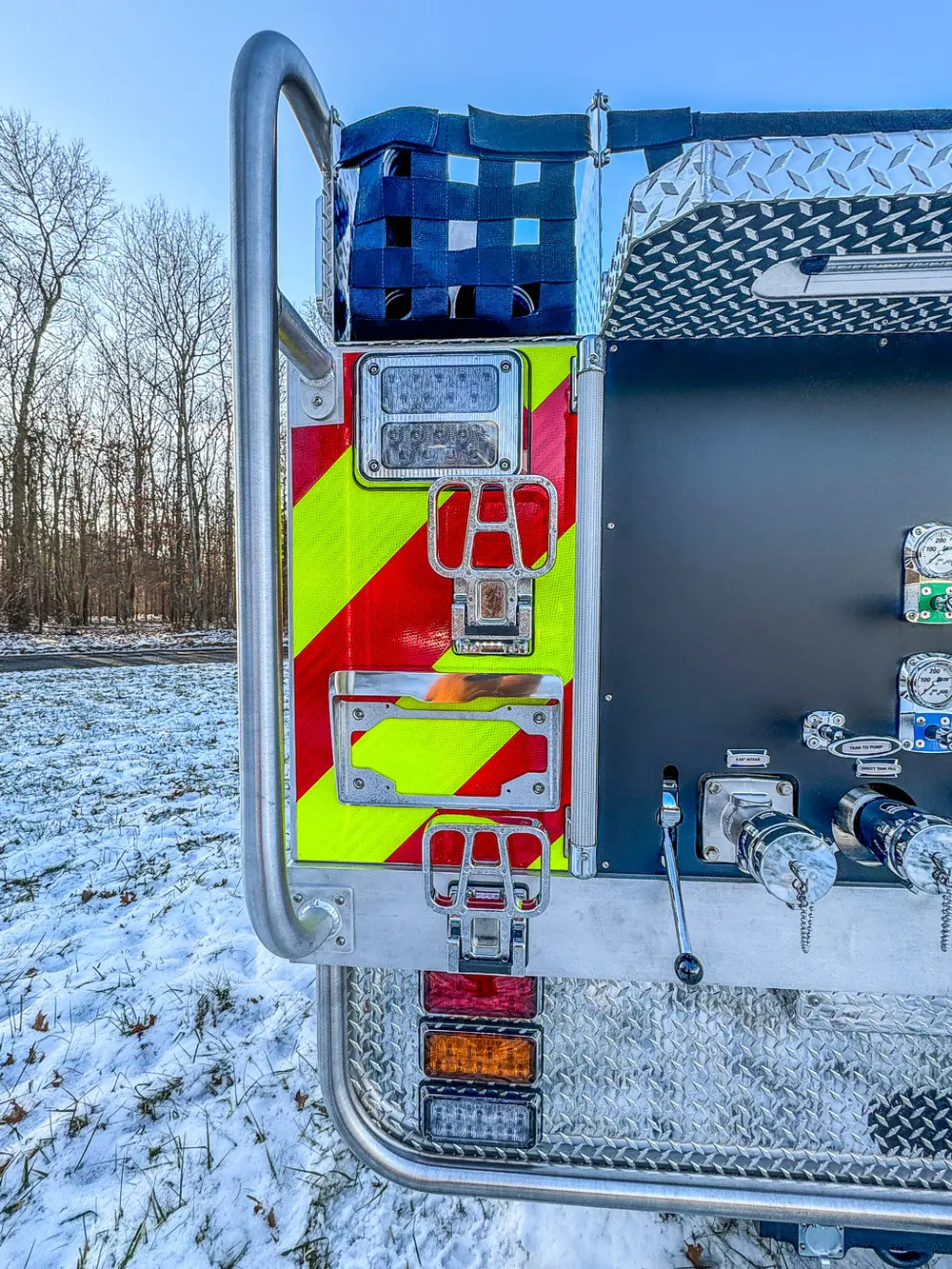 Rear corner close-up with chevron striping, warning lights, and connection points.