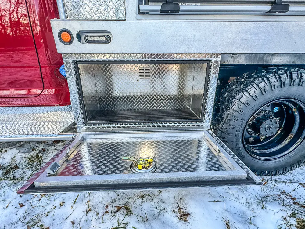 Open lower side compartment with fold-down tray near the rear wheel.