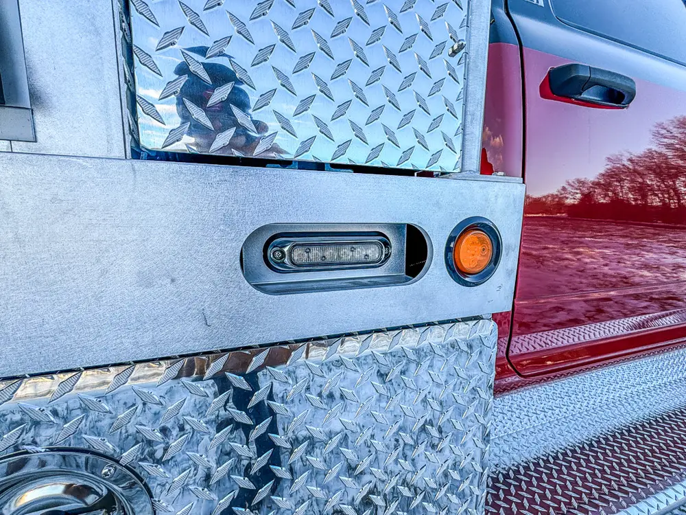 Close-up of side body marker light and diamond-plate panel.