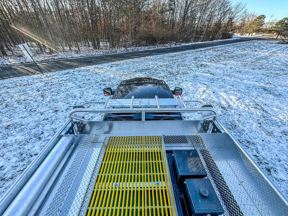 Top-deck view over the utility body with yellow grated walkway and rails.