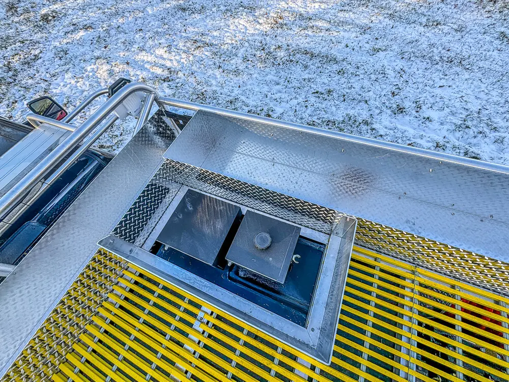 Close-up of yellow grated deck section and surrounding handrails.
