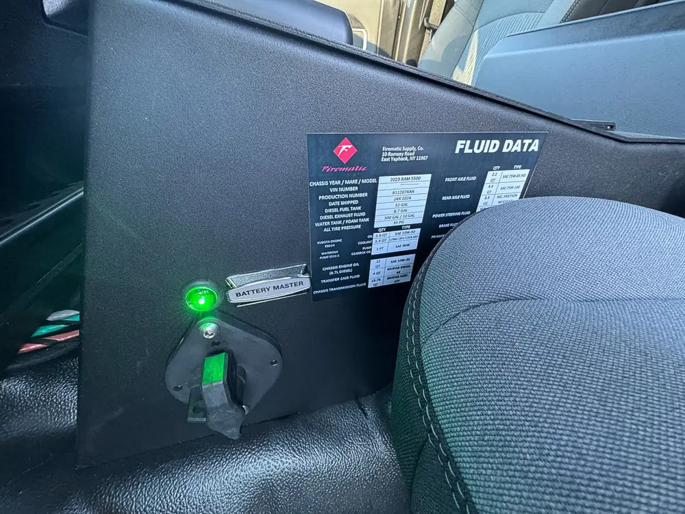 Cab interior close-up with fluid data label and indicator light behind the seat.