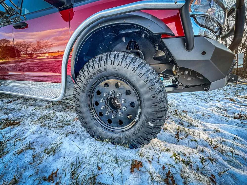 Close-up of the front wheel, tire tread, and fender flare.
