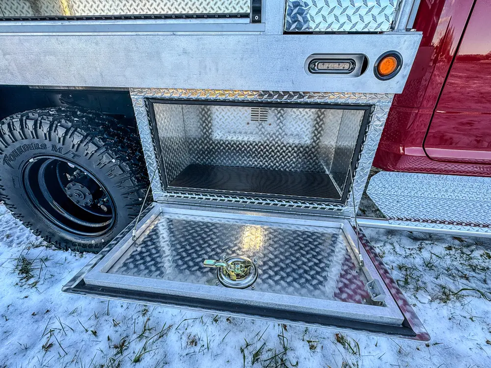 Open lower side compartment with a fold-down tray door and empty storage space.
