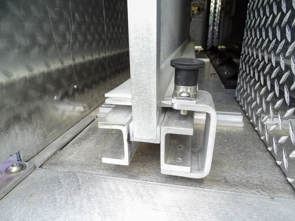 Exterior view of small fire truck showing cab, body compartments, and wheel/tire area.