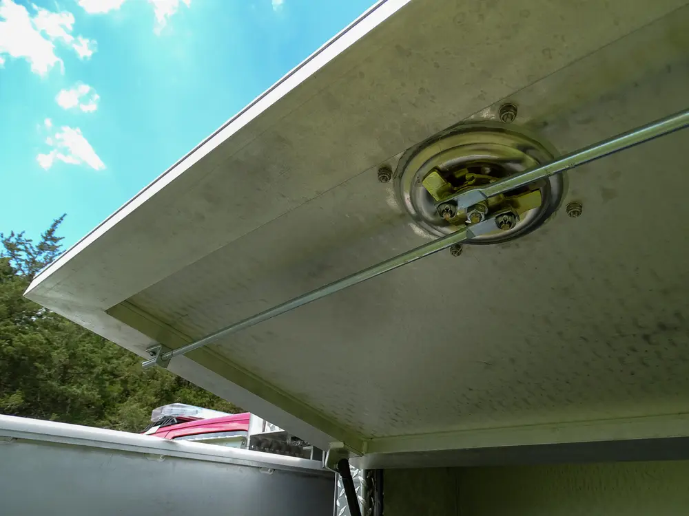 Exterior view of small fire truck showing cab, body compartments, and wheel/tire area.