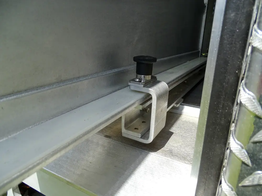 Exterior view of small fire truck showing cab, body compartments, and wheel/tire area.