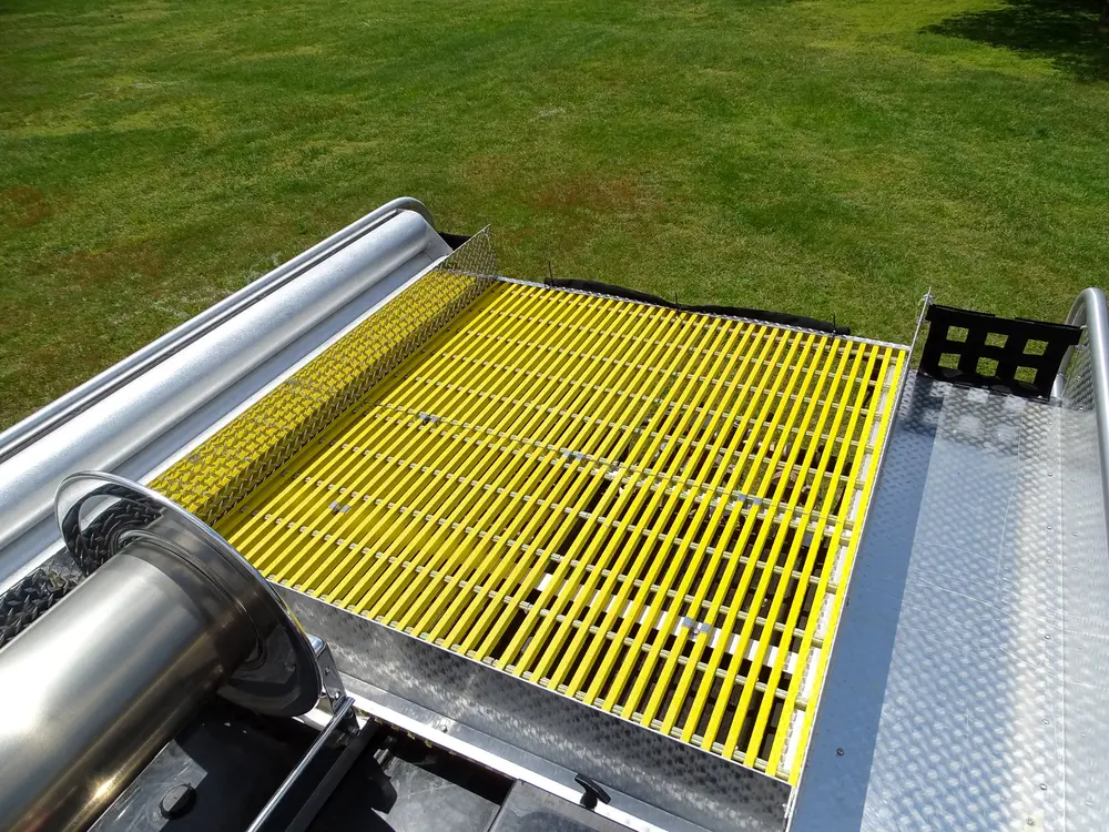 Exterior view of small fire truck showing cab, body compartments, and wheel/tire area.