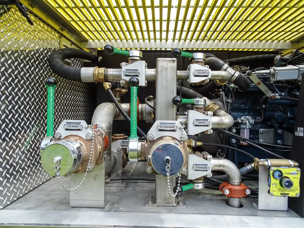 Exterior view of small fire truck showing cab, body compartments, and wheel/tire area.