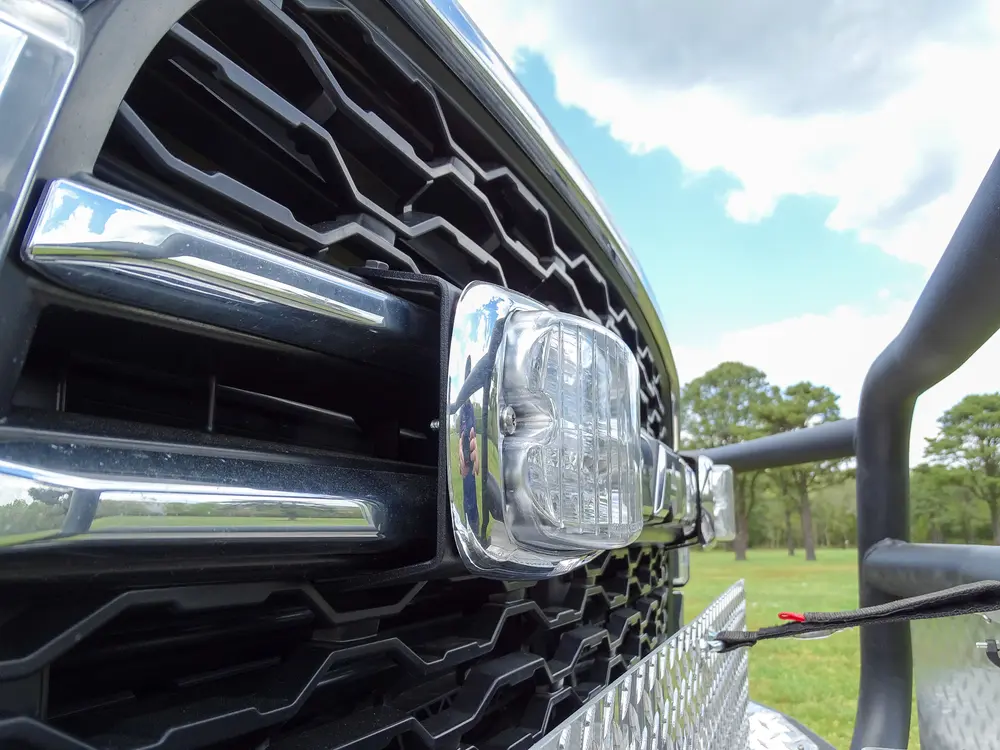 Exterior view of small fire truck showing cab, body compartments, and wheel/tire area.
