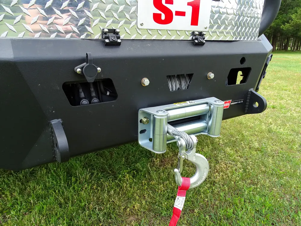 Exterior view of small fire truck showing cab, body compartments, and wheel/tire area.