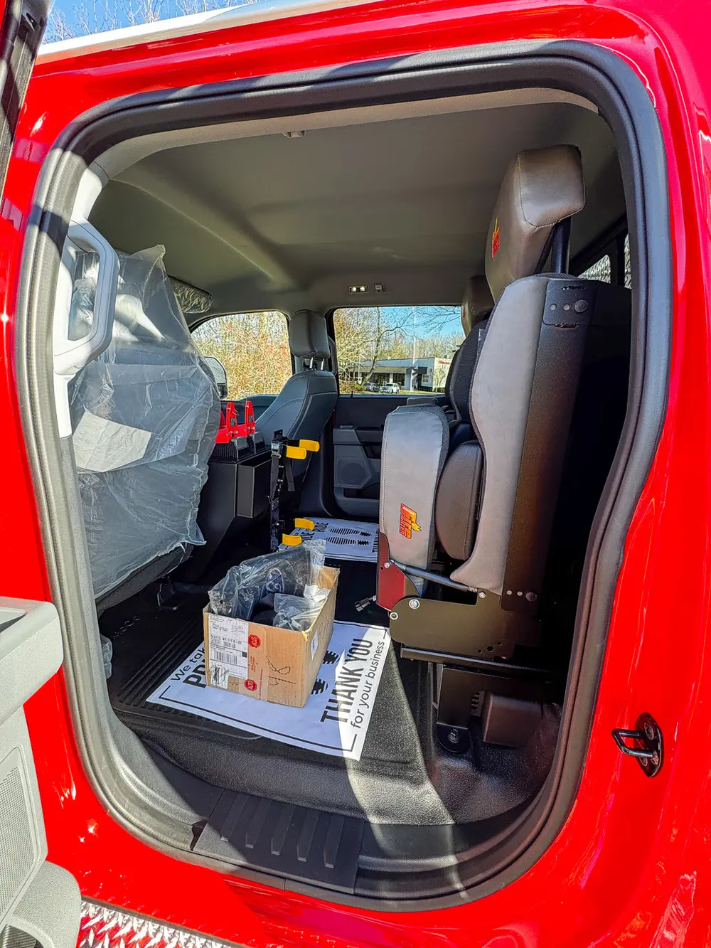Interior side view through open rear door toward front seats and console.