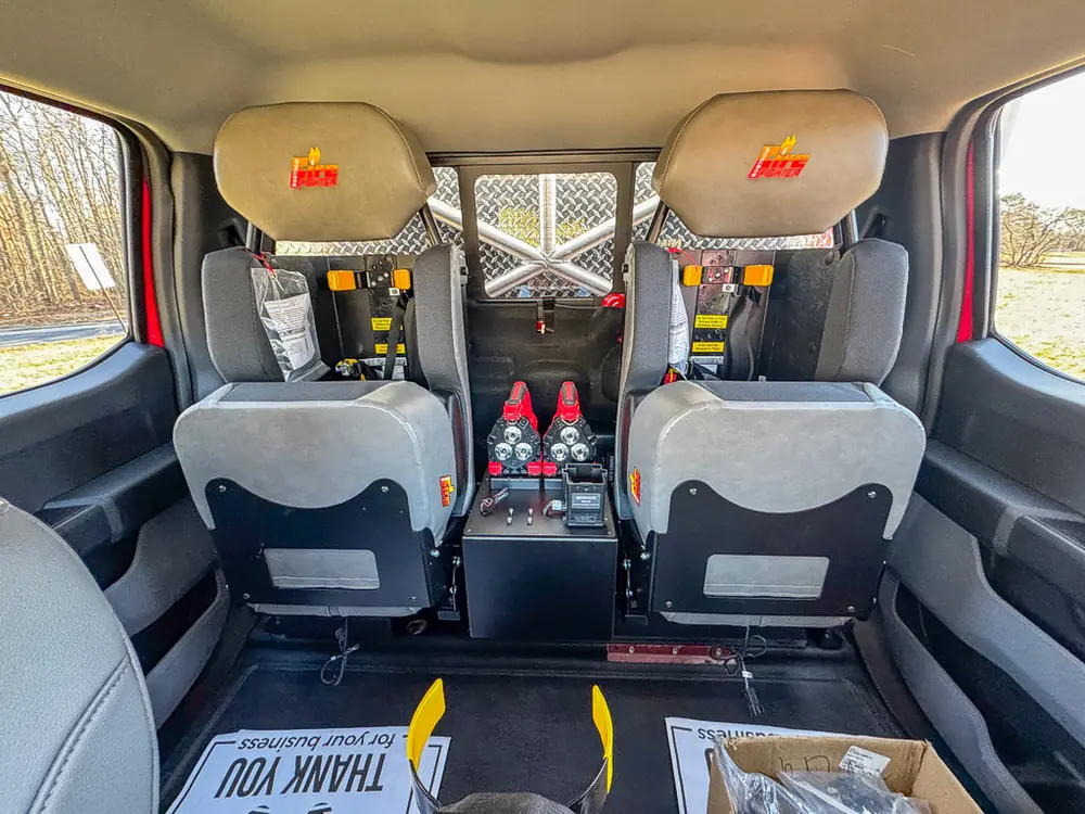 Straight-on rear seating view with child seats mounted behind front seats.