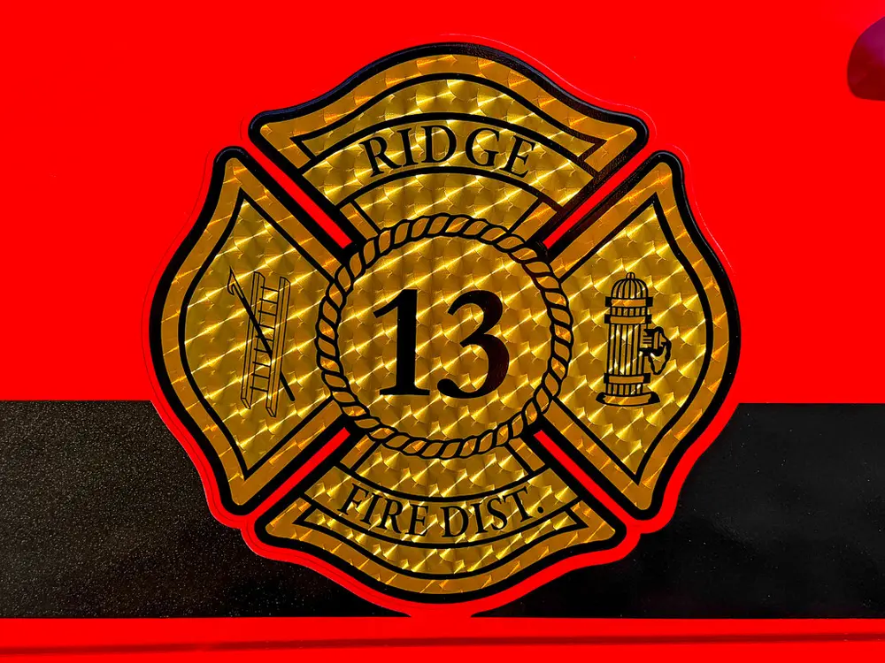 Close-up of fire department crest and number decal on the red cab door.