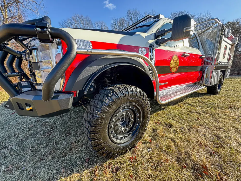 Front-left exterior angle showing cab, utility body, and brush guard.