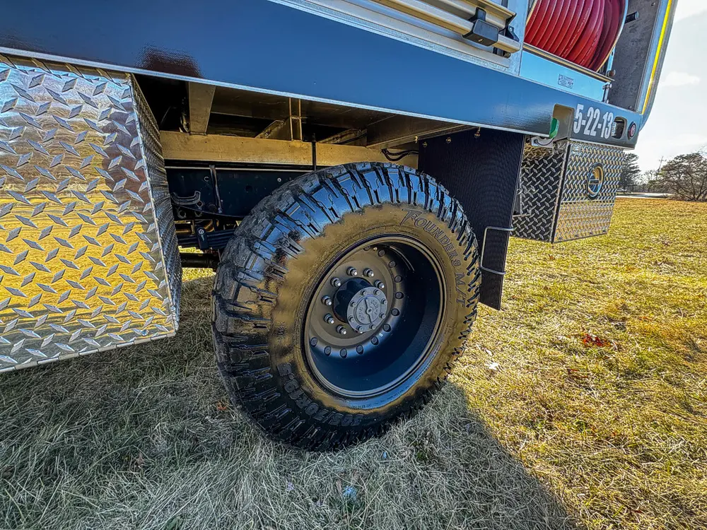 Close-up of rear wheel, tire, and lower side body panel.