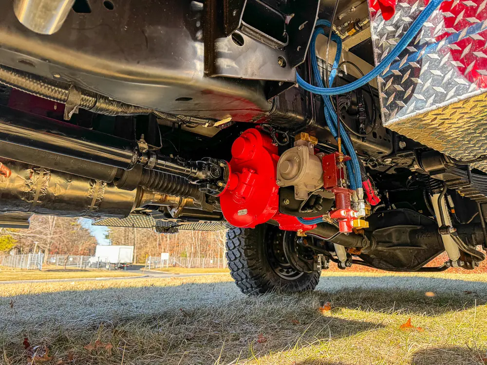 Underside rear chassis view showing driveline, suspension, and red differential housing.