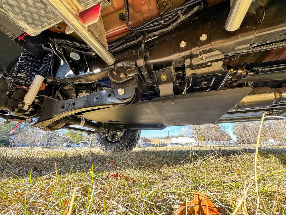 Undercarriage side view showing frame components and driveshaft.