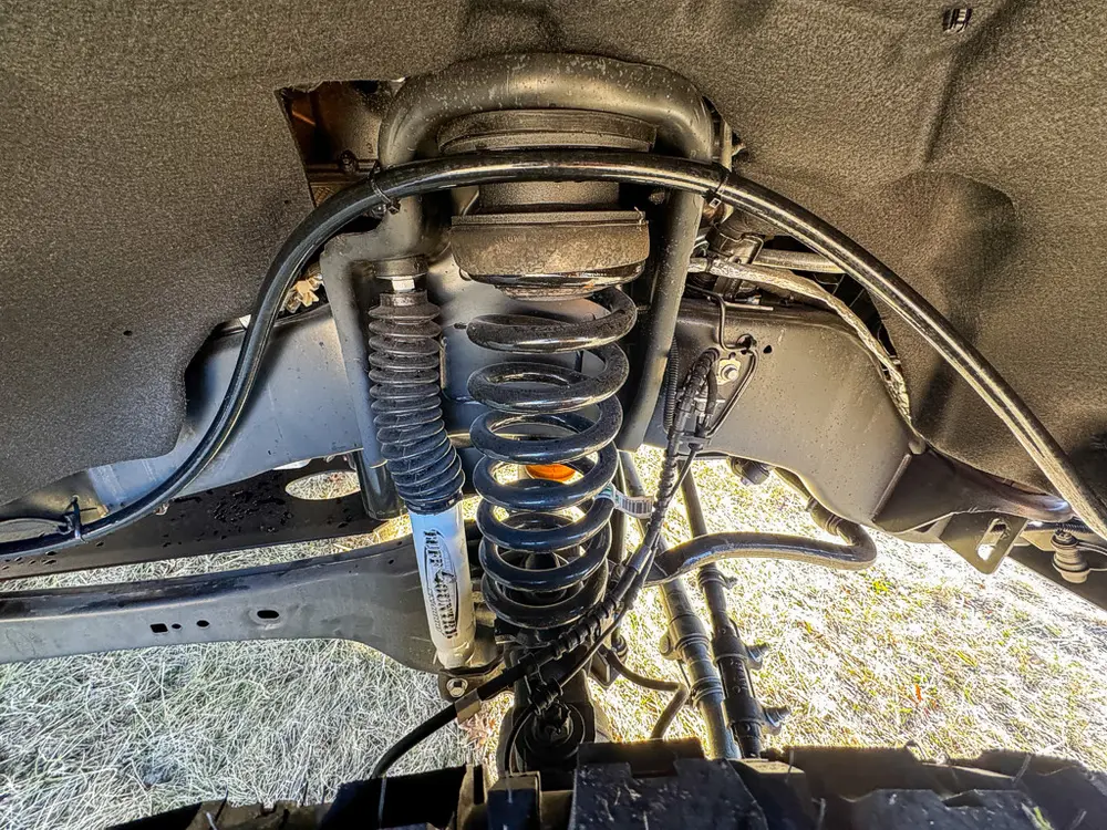 Front suspension close-up showing spring and steering linkage components.