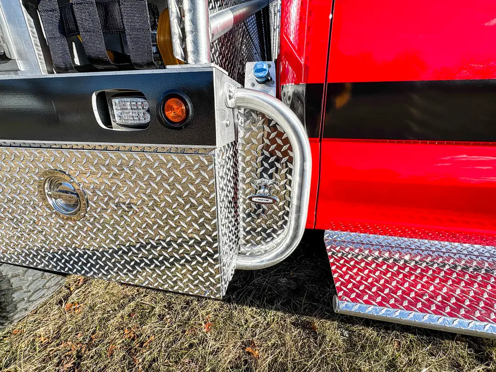 Diamond-plate body corner close-up with marker light and latch hardware.