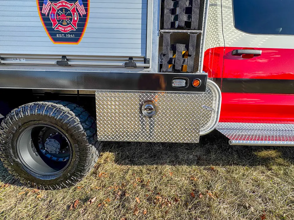 Lower side body and rear wheel area with closed compartment doors.