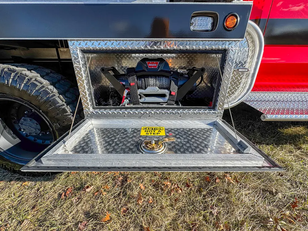 Open lower side compartment with fold-down tray and mounted equipment.