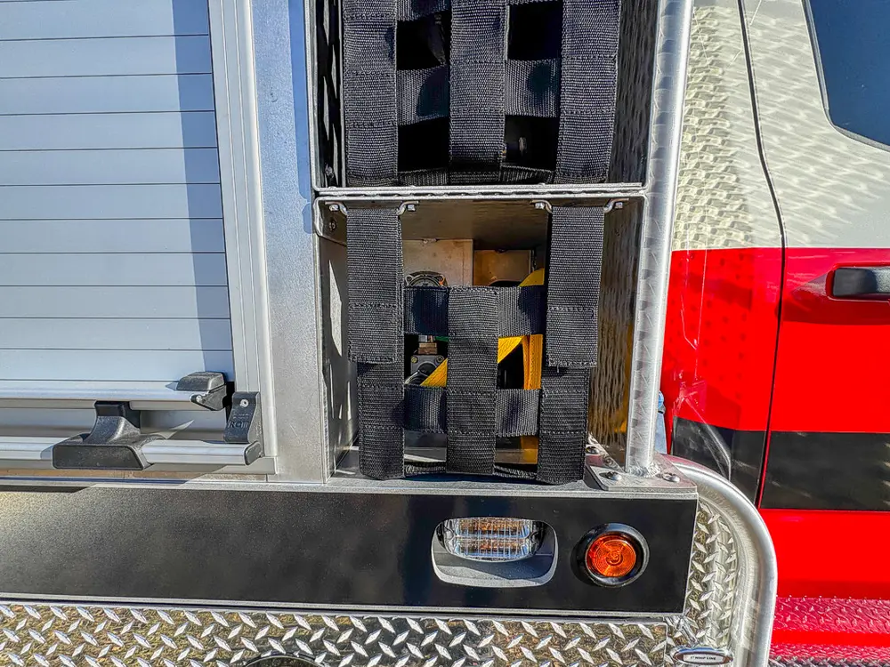 Open vertical side compartment with mounted tool brackets.