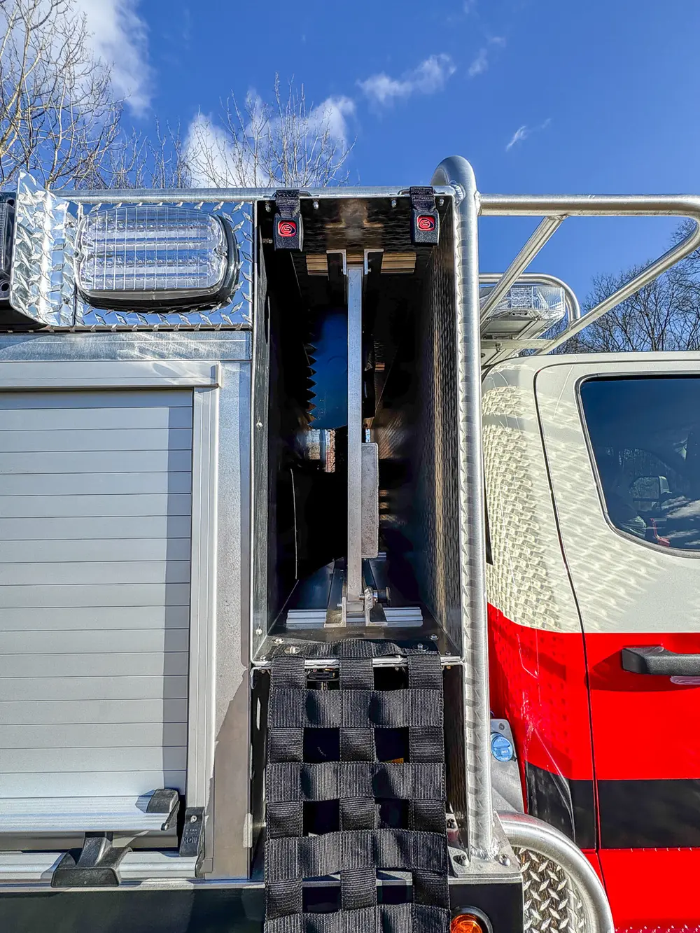 Open narrow vertical side compartment beside the roll-up body door.