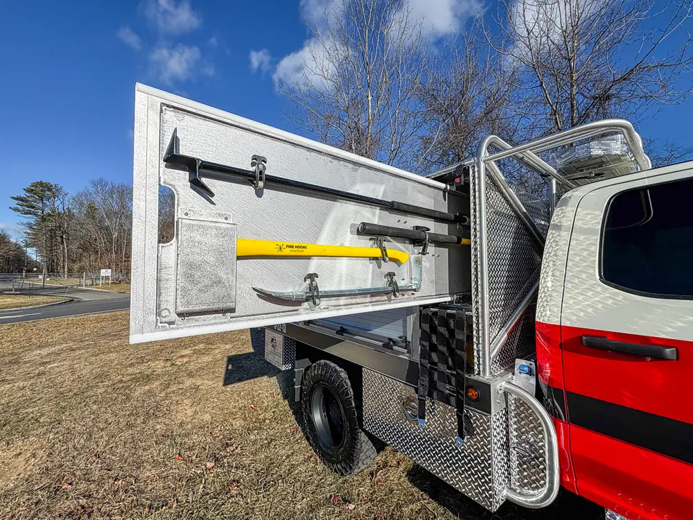 Open side door with a mounted yellow securing strap on the interior panel.