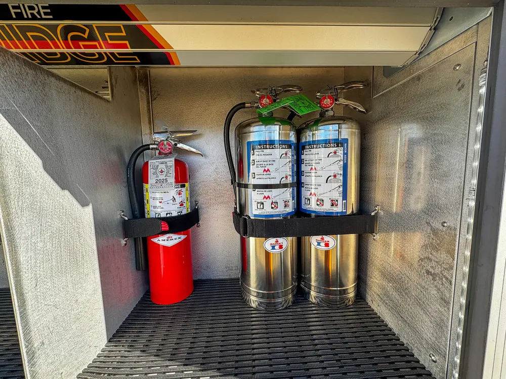 Compartment interior close-up with extinguisher and mounted cylinders.