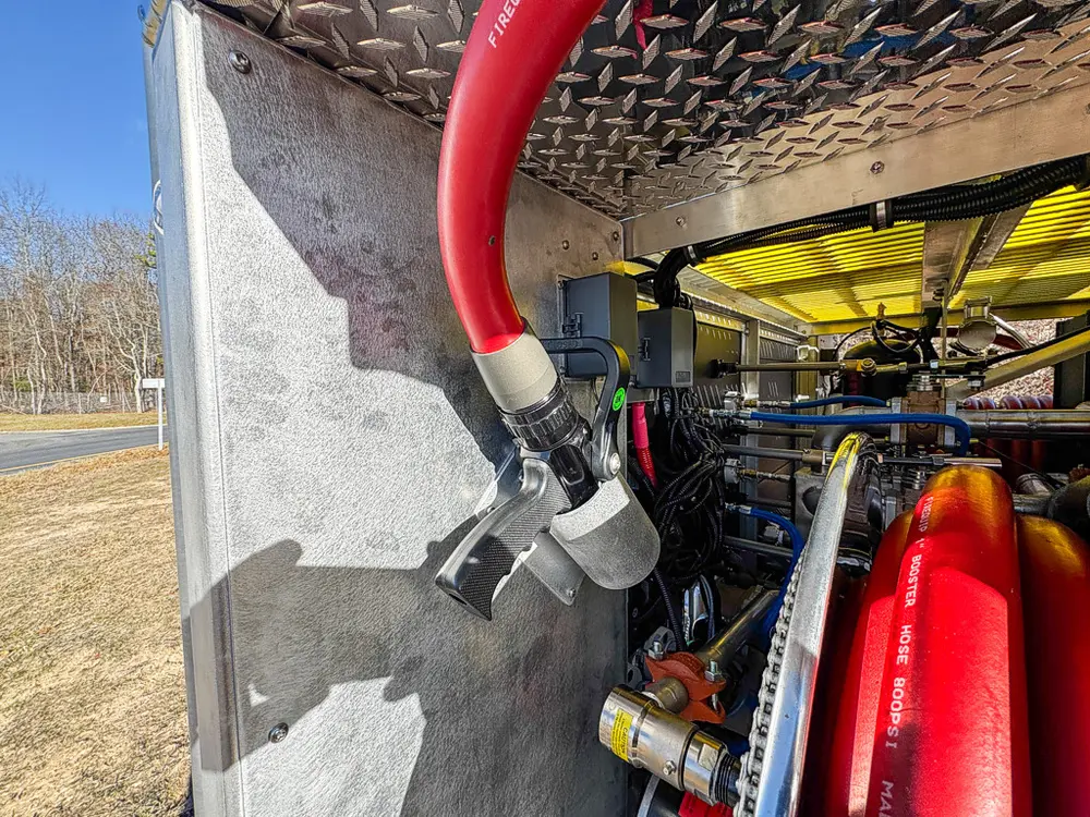 Compartment close-up showing red hose connection and nearby plumbing.