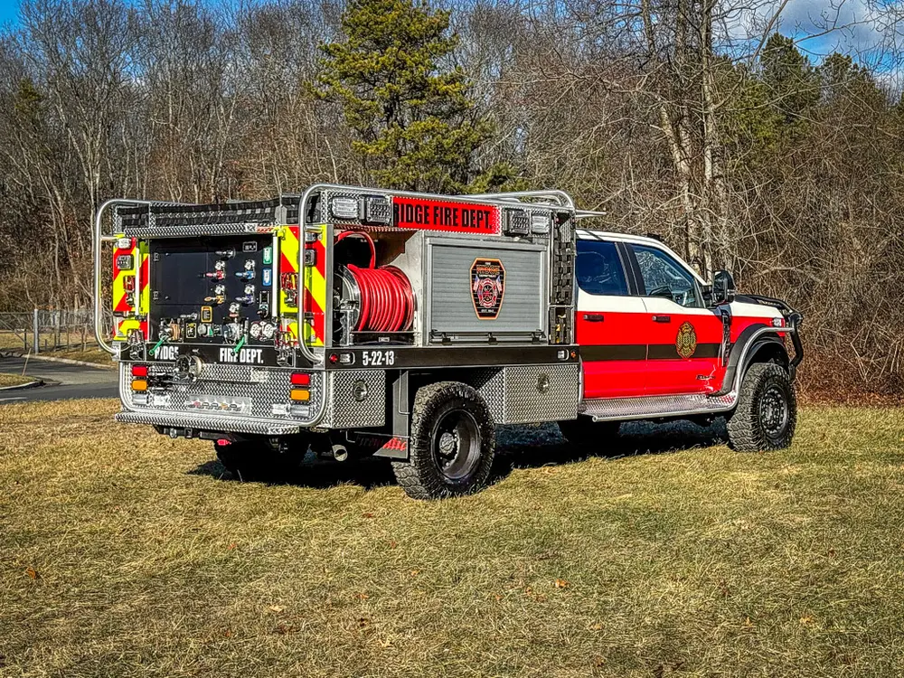 Rear-left three-quarter view showing the pump panel and rear hose reel.