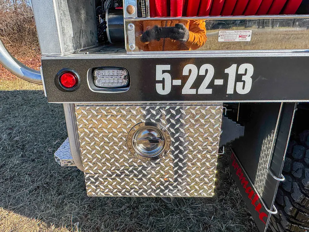 Rear corner close-up of lower body panel, marker light, and tow ring.