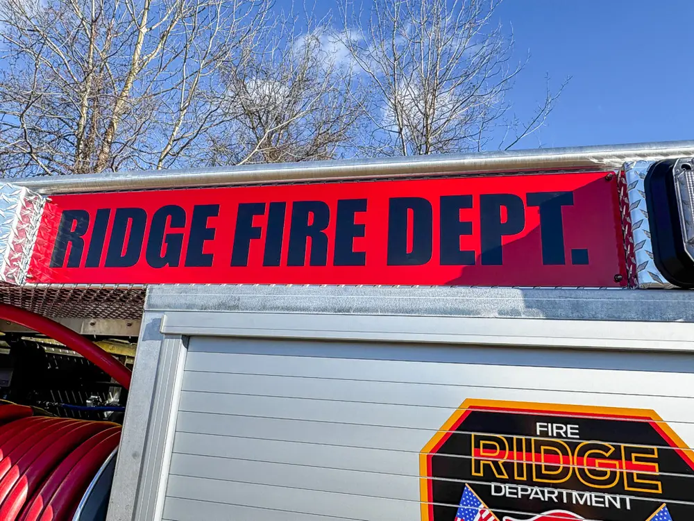 Upper side body close-up with fire department lettering above the compartment.